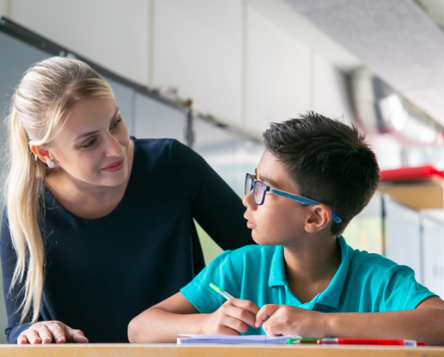 Teacher Helping school boy in class